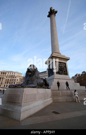 Les touristes autour de l'usine à la base de Nelsons Column à côté d'un lion. Banque D'Images