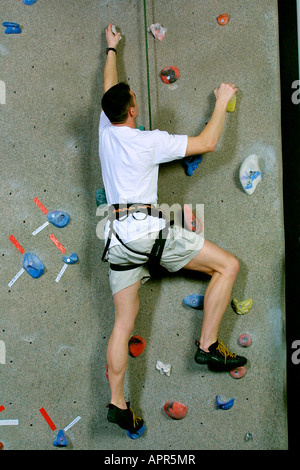 Jeune homme escalade une piscine mur d'escalade USA Banque D'Images