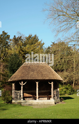 Un belvédère construit avec des matériaux naturels avec toit de chaume en hiver à West Dean Gardens, West Sussex, Angleterre, Royaume-Uni Banque D'Images