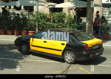 Vue de côté et arrière vue de Barcelone ville emblématique Espagnol noir et jaune taxi scène de rue devant le bar animé de chaussée Catalogne Espagne Europe UE Banque D'Images