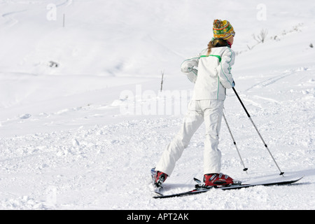 Femme paysage s'appuyant sur des bâtons de ski Horizontal image de belle femme mince en blanc et vert skisuit menant sur des bâtons de ski Banque D'Images