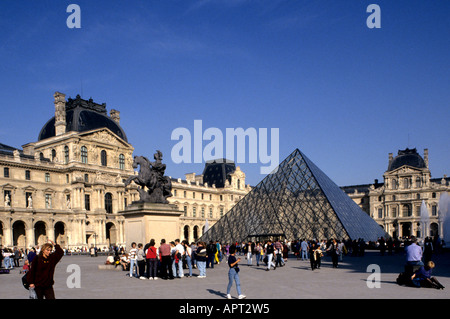 La pyramide de verre du Louvre conçue par I.M. Pei dans la cour Napoléon du complexe du palais du musée du Louvre, entourée de touristes. Banque D'Images
