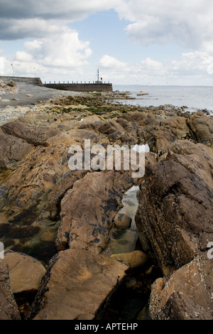 Plage rocheuse à Annalong regardant vers la jetée du port. Banque D'Images