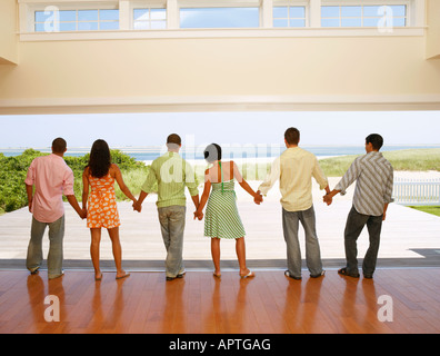 Multi-ethnic friends holding hands at beach resort Banque D'Images