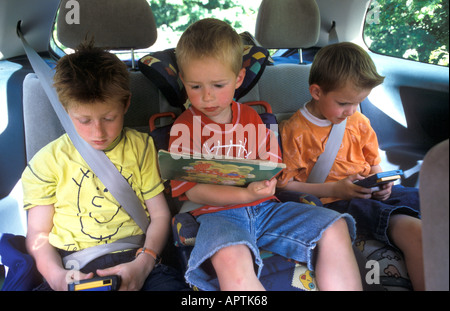 Trois garçons assis à l'arrière d'une voiture Banque D'Images