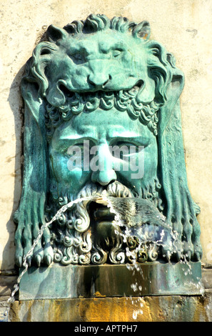 Masque de fontaine en bronze représentant Hercule à la Place de la République à Arles, France. Hercule mythologique portant la peau du lion de Némée avec vert-de-gris vert Banque D'Images