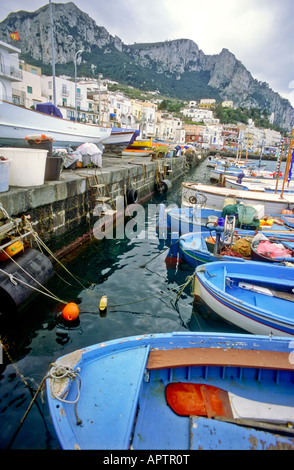 Bateaux Gozzi Marina Grande Waterfront Capri Italie // CAPRI, Italie — bateaux traditionnels en bois amarrés au front de mer à Marina Grande. Les navires colorés, connus sous le nom de gozzi, flottent dans les eaux cristallines du port, avec les bâtiments pittoresques de l'île qui s'élèvent en arrière-plan. Banque D'Images
