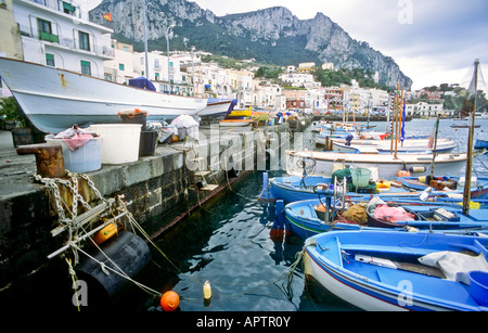 Bateaux Gozzi Marina Grande Waterfront Capri Italie // CAPRI, Italie — bateaux traditionnels en bois amarrés au front de mer à Marina Grande. Les navires colorés, connus sous le nom de gozzi, flottent dans les eaux cristallines du port, avec les bâtiments pittoresques de l'île qui s'élèvent en arrière-plan. Banque D'Images