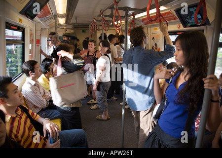 Les navetteurs et les touristes à bord du Skytrain de Bangkok, Thaïlande Banque D'Images