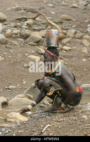 La collecte de l'eau femme toposas à partir d'une flaque, Soudan Banque D'Images