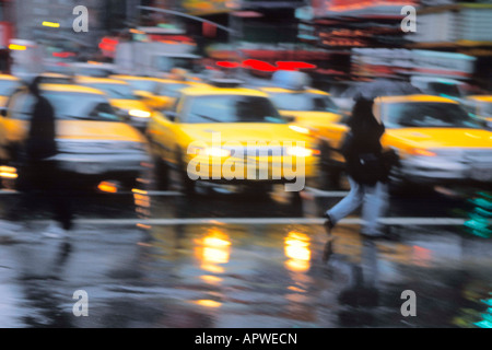 Pluie de New York.Personnes traversant la rue humide par un jour de pluie sur Broadway et Times Square.Pluie.Congestion routière New York Theatre District. Banque D'Images