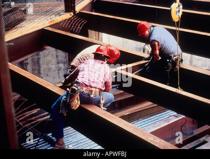 Chantier de construction trois travailleurs de casque assis sur des poutres en acier haut sur un bâtiment qui monte à New York City USA Banque D'Images