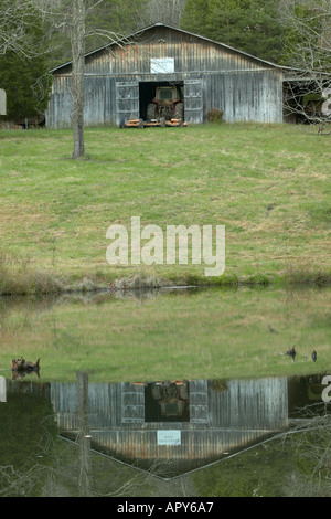 Ancienne grange et tracteur avec étang de ferme à l'automne, Tennessee Banque D'Images