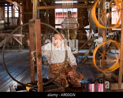 Vieille Femme se visse dans la filature de soie de lotus qui est une industrie artisanale locale au Lac Inle au Myanmar Banque D'Images