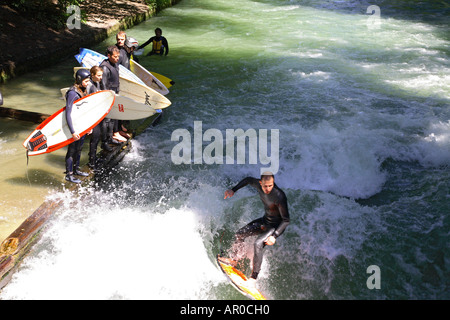 Surf surfer dans l'Eisbach Rivière Jardin Anglais de Munich, Allemagne Banque D'Images