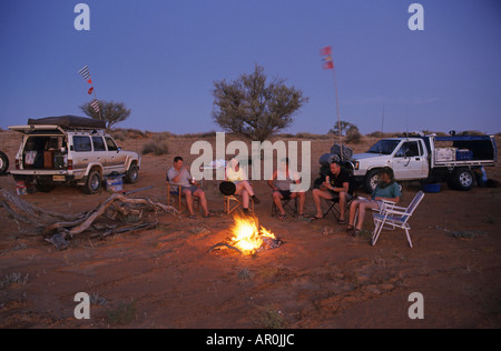 Simpson Desert camp 4WD en Australie, Amérique du Sud, l'Australie du Sud, 4 roues motrices et les touristes s'asseoir autour d'un feu de camp, Simpson Banque D'Images