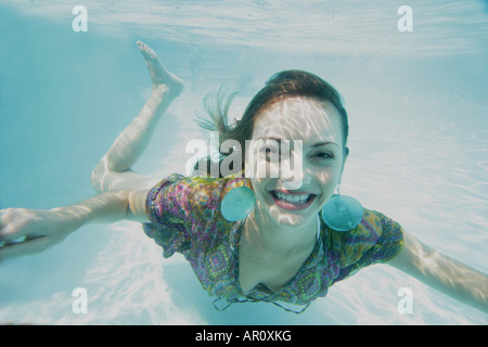 Pleinement heureuse jeune femme habillée sous l'eau. Banque D'Images