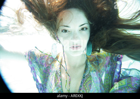 Jeune femme habillée entièrement sous l'eau. Banque D'Images
