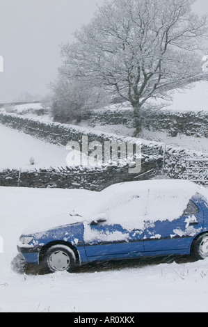 Une voiture abandonnée sur la puce dans le Lake District dans la neige lourde UK Banque D'Images