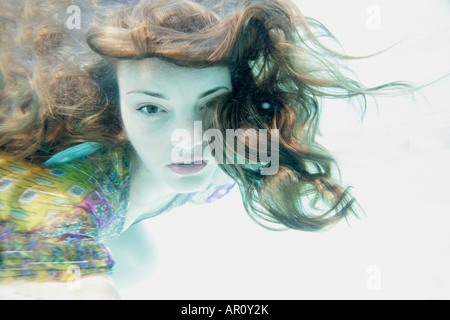 Young woman floating underwater. Banque D'Images