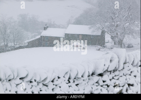 Une vieille ferme sur la puce dans le Lake District dans la neige lourde UK Banque D'Images