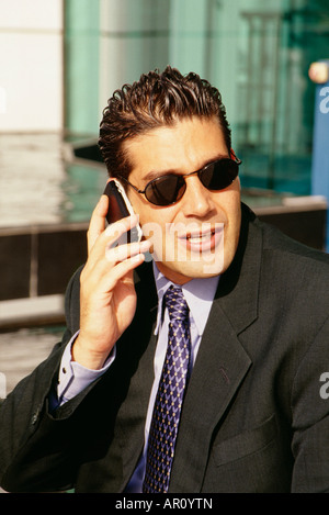 Un homme vu la conversation sur le téléphone cellulaire lors d'une journée ensoleillée. Banque D'Images