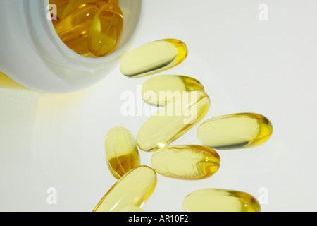 Des capsules d'huile de poisson de renverser un récipient Banque D'Images