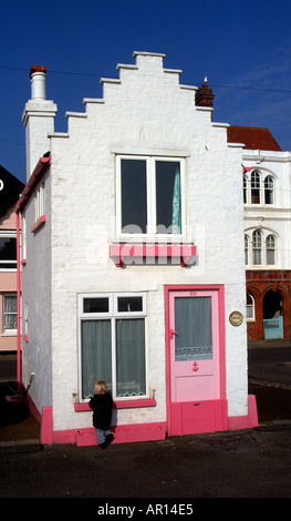 Fantasia une petite maison dans le Suffolk Aldeburgh en Angleterre avec un tout-petit enfant d'essayer de regarder par la fenêtre Banque D'Images