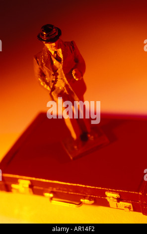 Toy businessman standing on brief case Banque D'Images