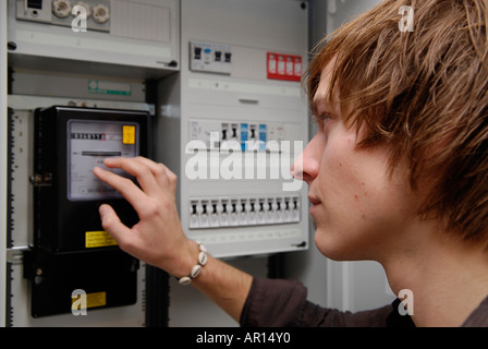 L'homme lit les compteurs électriques Banque D'Images