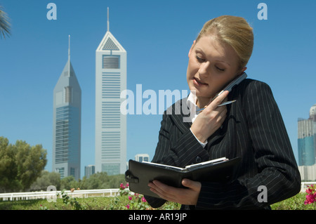 Young Businesswoman outdoors avec tours de bureaux moderne vu dans l'arrière-plan Banque D'Images