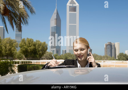 Young Businesswoman outdoors avec tours de bureaux moderne vu dans l'arrière-plan Banque D'Images