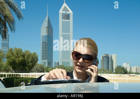 Young Businesswoman outdoors avec tours de bureaux moderne vu dans l'arrière-plan Banque D'Images