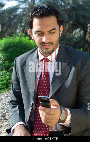 Young man holding a cell phone and smiling Banque D'Images