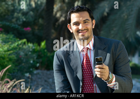 Young man holding a cell phone and smiling Banque D'Images