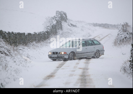 Une BMW conduite sur une puce dans le Lake District dans la neige lourde UK Banque D'Images