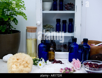 Huiles essentielles dans une armoire en bois traditionnel avec des herbes fraîches et une bouteille de verre de l'Amande Douce huile de porteur. Banque D'Images