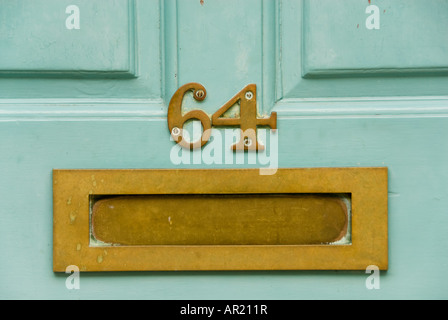 Close-up de couleur vive en letterbox laiton porte du numéro 64 Banque D'Images