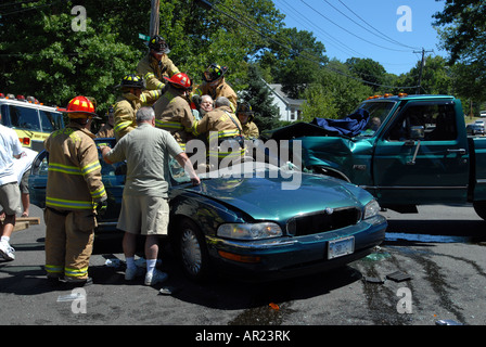 Un homme d'être dégagé à partir d'un accident de voiture par les pompiers en utilisant les "mâchoires de la vie" dans le Connecticut, USA Banque D'Images