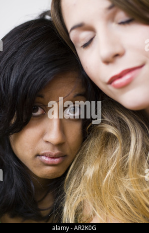 Deux copines dans l'amour, la femme marron clair avec les yeux fermés et la femme darkharied avec de grands yeux ouverts Banque D'Images