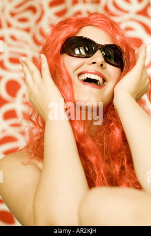 Portrai d'une femme avec une perruque et des lunettes de soleil rouge Banque D'Images