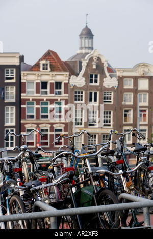 AMSTERDAM HOLLAND BIKES garés dans le parc à vélos de plusieurs étages PRÈS DE LA GARE CENTRALE à pignons avec de vieux bâtiments en arrière-plan Banque D'Images