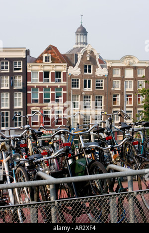 AMSTERDAM HOLLAND BIKES garés dans le parc à vélos de plusieurs étages PRÈS DE LA GARE CENTRALE à pignons avec de vieux bâtiments en arrière-plan Banque D'Images