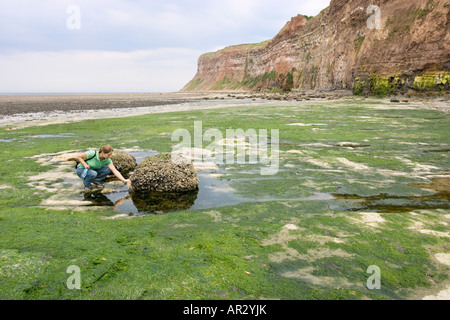 Une jeune femme respectueuse de l'esprit, prendre le fil de pêche et de litière de Lyon Plage. North Yorkshire, UK Banque D'Images