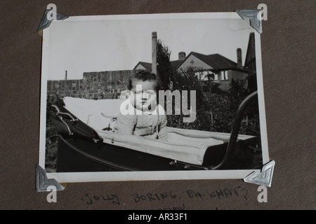 Nostalgie vieille photographie noir et blanc montrant bébé de 6 mois dans la région de old fashioned grand pram prises en milieu des années 1950 Banque D'Images