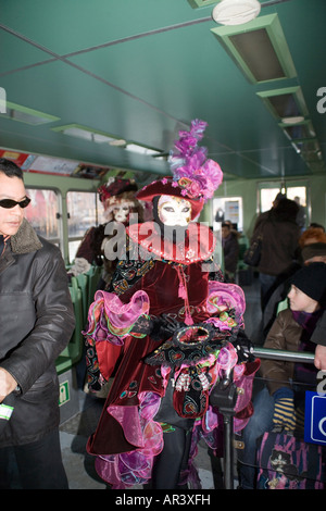 Femme en costume et masque de reveler aller au carnaval sur un bateau-bus, un vaporetto, sur le Grand Canal à Venise. Italie Banque D'Images