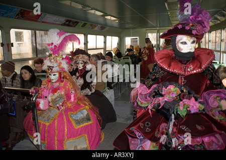 Les fêtards s'en masque et costume pour le carnaval va sur un bateau-bus, un vaporetto, sur le Grand Canal à Venise. Italie Banque D'Images