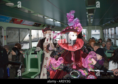 Femme en costume et masque de reveler aller au carnaval sur un bateau-bus, un vaporetto, sur le Grand Canal à Venise. Italie Banque D'Images