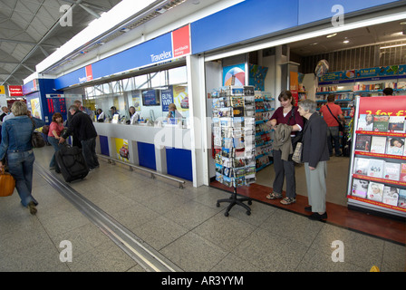 Les passagers (mère et fille) à l'intérieur de l'aéroport de Stansted le choix d'une carte postale à envoyer home Banque D'Images