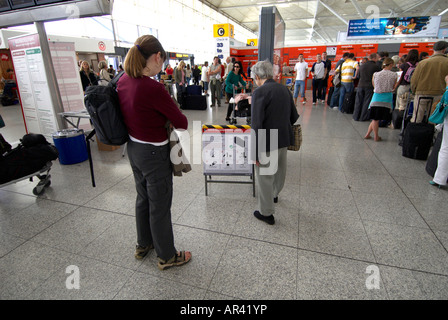 Les passagers (mère-fille) à l'intérieur de l'aéroport de Stansted - Les deux principales personnes lisant le signe dans cette photo sont photo publié Banque D'Images